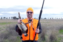 Yolo County Pheasants Forever vertical banner standing in a field next to a white trailer