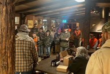 Hunters gathered inside a lodge for a pre-hunt safety briefing